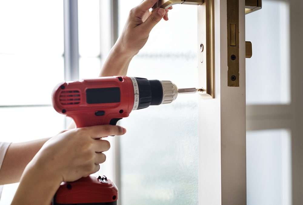 woman using electronic drill installing door
